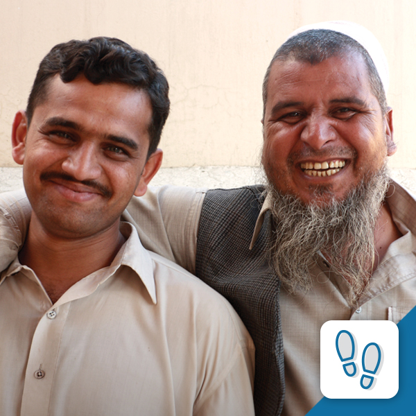 Two middle eastern men smiling and hugging